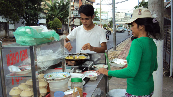 Thanh Tân phụ ba mẹ làm bánh khọt bán trên đường Lý Thường Kiệt, P.Phú Cường, TP Thủ Dầu Một, Bình Dương - Ảnh: L.N.H.